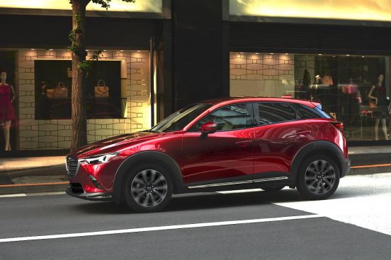 Image of a red Mazda CX-3 parked on a city street.