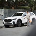 Commuters standing near the 2026 Mazda CX-70 PHEV
