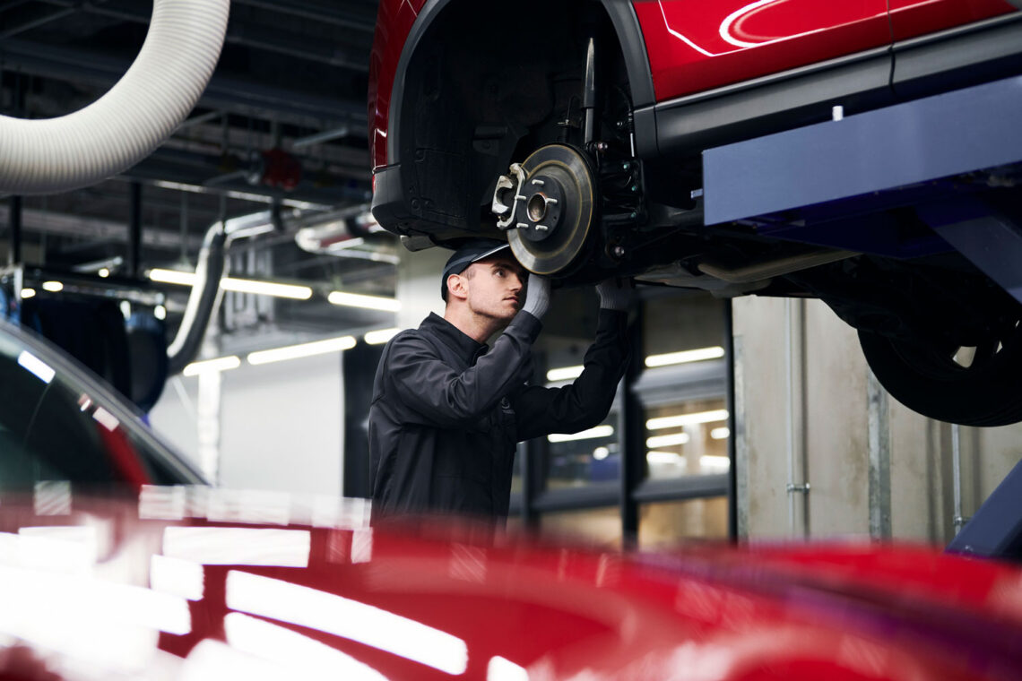 Mazda service technician working on brakes