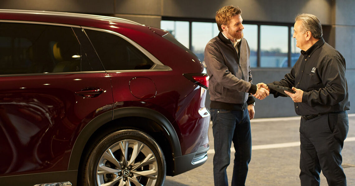 Mazda recall service technician shaking hands with a customer